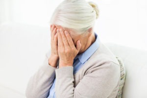 senior woman suffering from headache or grief